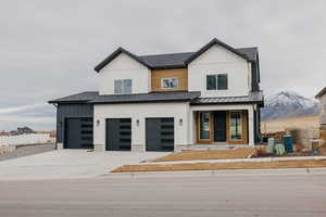 Modern inspired farmhouse featuring a garage and a mountain view