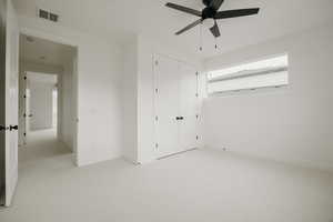 Bedroom featuring light colored carpet, a closet, and ceiling fan