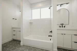 Bathroom featuring tile patterned flooring, vanity, and  shower combination