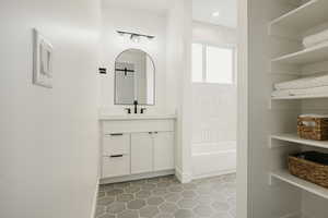 Bathroom with shower / bathtub combination, vanity, and tile patterned flooring