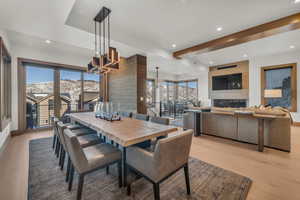 Dining room featuring a mountain view, a healthy amount of sunlight, a chandelier, and light wood-type flooring