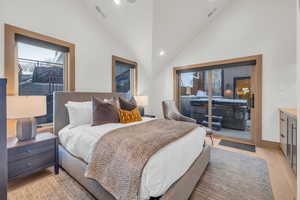 Bedroom featuring high vaulted ceiling and light wood-type flooring