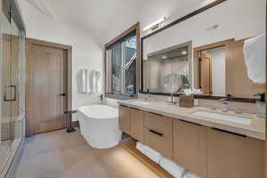 Bathroom featuring vanity, separate shower and tub, and vaulted ceiling