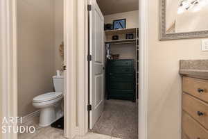 Bathroom featuring vanity, tile patterned flooring, and toilet