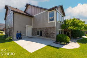 Rear view of house featuring a patio and a lawn