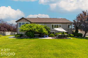 Rear view of house with a yard and a patio area