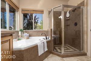 Bathroom featuring vanity, tile patterned floors, and shower with separate bathtub