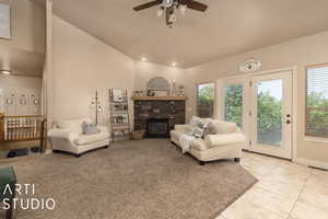 Living room with lofted ceiling, a fireplace, and ceiling fan