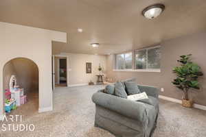 Carpeted living room with a textured ceiling