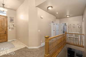 Foyer entrance featuring light colored carpet