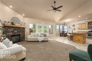 Living room featuring ceiling fan, lofted ceiling, sink, and a fireplace