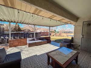 View of patio with an outdoor living space, a pool, and a playground