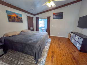 Primary Bedroom featuring access to exterior, vaulted ceiling, hardwood / wood-style floors, and ceiling fan