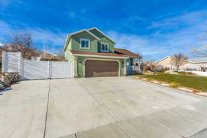 View of front of property featuring a garage and a front lawn