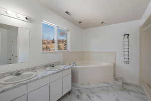 Bathroom featuring vanity and a tub to relax in