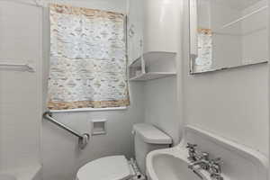 Bathroom featuring tiled shower / bath and toilet