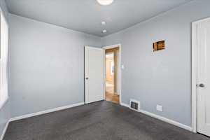 Spare room with dark colored carpet