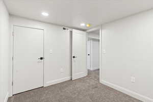 Unfurnished bedroom with light colored carpet and a textured ceiling