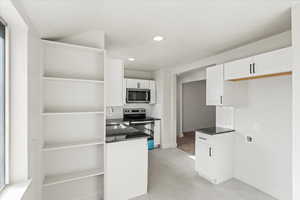 Kitchen with white cabinetry, tasteful backsplash, and stainless steel appliances