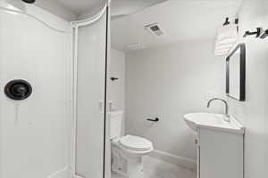 Bathroom with walk in shower, vanity, toilet, and a textured ceiling