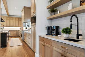 Kitchen featuring sink, backsplash, light hardwood / wood-style flooring, and appliances with stainless steel finishes