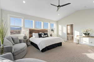 Primary Carpeted bedroom with vaulted ceiling, ceiling fan, and ensuite bathroom