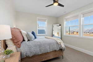 Carpeted bedroom with a mountain view and ceiling fan