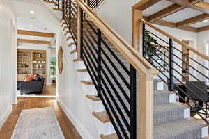 Stairs featuring hardwood / wood-style flooring and beam ceiling