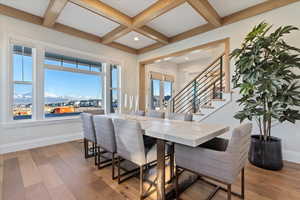 Dining space with beam ceiling, a mountain view, coffered ceiling, and light wood-type flooring