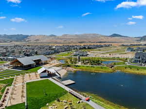 Aerial view of park and Cove building including Daybreak amenities along watercourse and mountain view