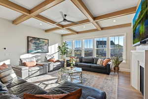 Living room featuring hardwood / wood-style flooring, ceiling fan, coffered ceiling, and beam ceiling