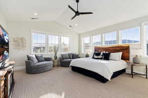 Primary Barpeted bedroom featuring ceiling fan, vaulted ceiling, and multiple windows