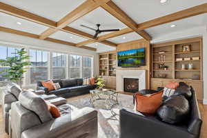 Living room featuring plenty of natural light, coffered ceiling, and built in shelves