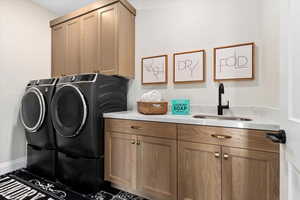 Washroom featuring cabinets, separate washer and dryer, and sink