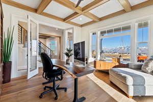 Home office featuring hardwood / wood-style flooring, coffered ceiling, and beamed ceiling