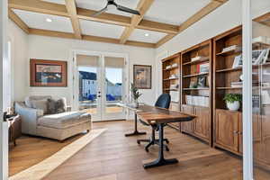 Office with french doors, coffered ceiling, light hardwood / wood-style flooring, and beamed ceiling