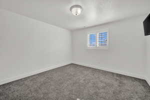 Empty room with a textured ceiling and carpet