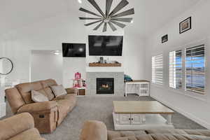 Carpeted living room with vaulted ceiling and a fireplace