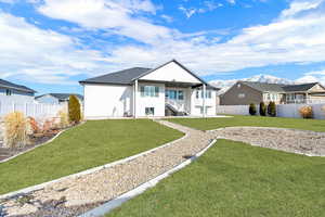 Back of house featuring a mountain view and a lawn