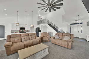 Living room with carpet and high vaulted ceiling