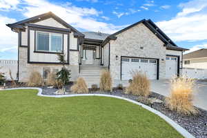 View of front of property with a garage and a front yard