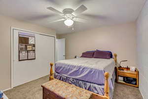 Bedroom with carpet flooring, ceiling fan, and a closet