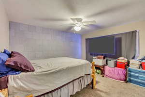 Carpeted bedroom with ceiling fan