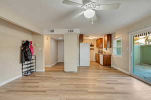 Unfurnished living room with ceiling fan and light hardwood / wood-style flooring