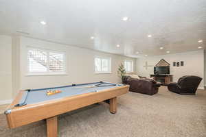 Rec room featuring pool table, a textured ceiling, and carpet flooring