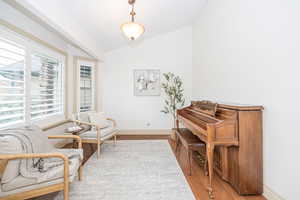 Living area with vaulted ceiling and hardwood / wood-style floors