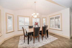 Dining room featuring an inviting chandelier and vaulted ceiling