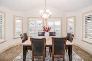 Dining area featuring lofted ceiling and a notable chandelier