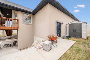 Exterior space with an outdoor fire pit, a deck, and a storage unit