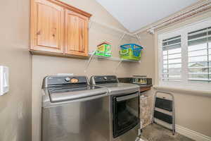 Clothes washing area featuring cabinets, separate washer and dryer, and heating unit